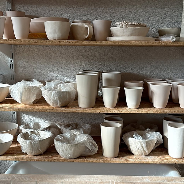 Gegossene und getöpferte Vasen, Tassen und Schalen trocknen vor dem Besuch des Brennofens